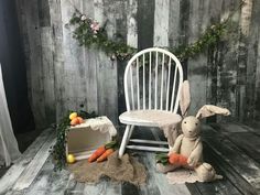 a white chair sitting on top of a wooden floor next to a stuffed animal rabbit