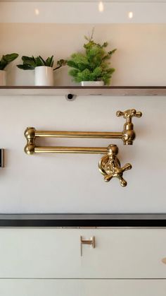 two brass faucets are on the wall in this kitchen