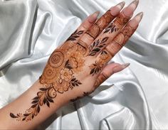 a woman's hand with henna tattoos on it