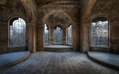 an empty room with several windows and stone steps