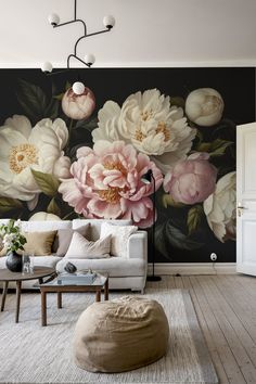 a living room with large flowers painted on the wall and furniture in front of it