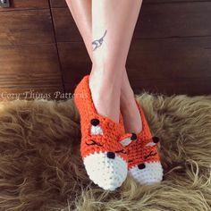 a close up of a person's legs wearing crocheted slippers with foxes on them