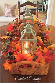 a basket filled with fall leaves and a lantern