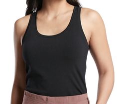 a woman wearing a black tank top and tan pants with her hands in her pockets