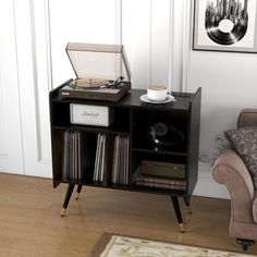 a record player sitting on top of a wooden table next to a couch and chair