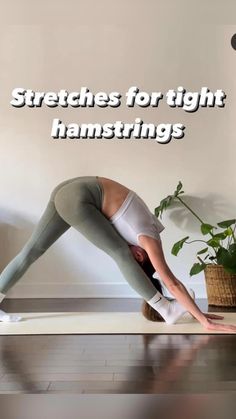 a woman is doing yoga in front of a plant