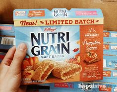 a person holding up a box of nutri grain soft baked treats in front of other boxes