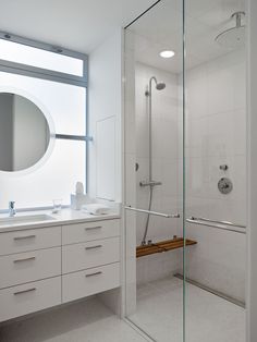 a white bathroom with two sinks and a large mirror on the wall over the shower