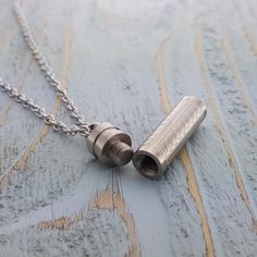 Gorgeous Stainless Steel Vial Necklace, I have suspended this gorgeous piece from a silver plated chain which can be customized to your desired length.  At the top of the vial a small threaded plug with a small rubber seal that makes the piece air and water tight.  You can pop some grains from your most favourite beach, a lock of hair, a little note or the remains of someone you wish to have close to your heart. This little secret measures 36 mm (1 1/2") tall (not including the loop at the top) Sterling Silver Necklace For Personal Use, Silver Locket Necklace With Adjustable Chain For Keepsake, Container Necklace, Vial Necklace, Pill Container, Cremation Necklaces, Urn Pendant, Hiding Places, Linking Rings