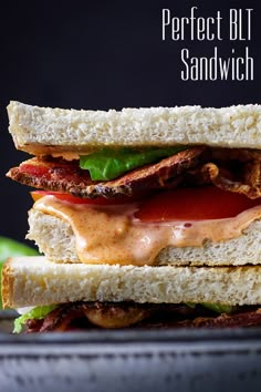 a sandwich with bacon, lettuce and tomato sauce on it sitting on a plate