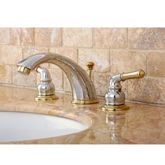 two golden faucets on a marble counter top