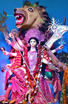 an elaborately decorated statue with a lion head on it's face and two swords in his hands