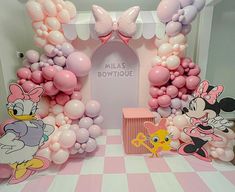 the balloon arch is decorated with pink and white balloons, minnie mouse figures, and other decorations