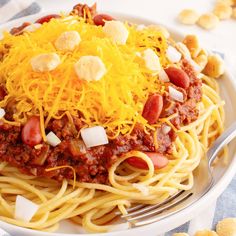 a white plate topped with spaghetti and chili