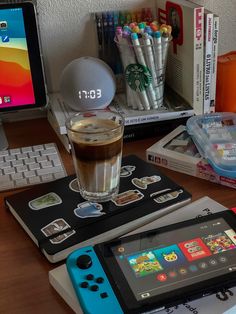 a cup of coffee sitting on top of a table next to a nintendo wii game controller