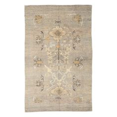 an antique rug with floral design on the front and back, in grey tones is shown