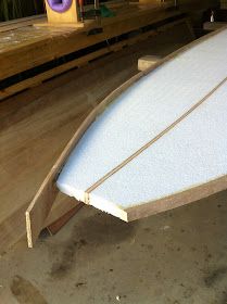 a white surfboard sitting on top of a wooden table