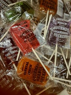 many candies are wrapped in plastic and sitting on top of each other with the words, gourmet suckers