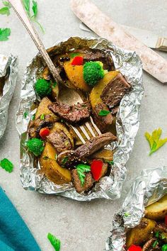 steak, broccoli and peppers in foil on a plate with a fork next to it