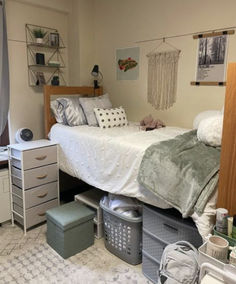 a bed room with a neatly made bed and lots of clutter on the floor