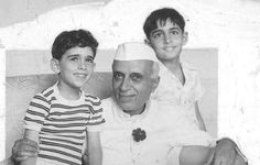 an old black and white photo of two boys and an older man sitting on a couch