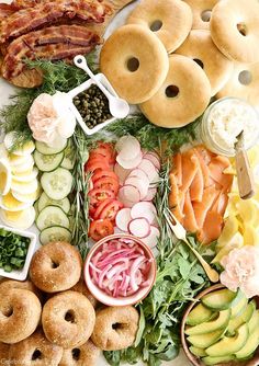 an assortment of food is laid out on a white plate with donuts, cucumbers, and other foods