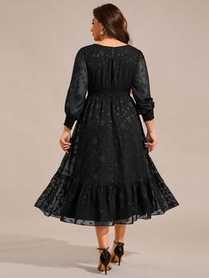 a woman wearing a black dress with long sleeves and a ruffled skirt, back view