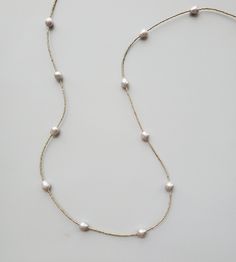 This long gray freshwater pearl strand is a jewelry collection building piece. Hand beaded with our best selling pearls as stations on this tiny bead strand. Shimmering in your choice of gold or silver, this necklace can be worn long or easily doubled.



Slip it over head with ease or use the handcrafted clasp to double it to fit your style. A elegant statement worn alone, but will create a luxe look when layered. The perfect delicate pearl strand!



Also available in white pearl. Luxury Single Strand Elegant Beaded Necklaces, Luxury Single Strand Beaded Necklace For Everyday, Elegant Gray Pearl Necklace, Elegant Silver Single Strand Long Necklace, Gray Pearl Necklace For Formal Occasions, Formal Gray Pearl Necklace, Elegant Long Gray Necklace, Gray Pearl Necklace, Sophisticated Jewelry