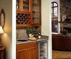 a kitchen with wooden cabinets and granite counter tops, along with a wine rack on the wall