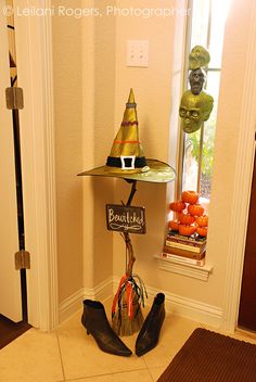 there is a shelf with hats on it in the entryway to a house that has been decorated for halloween