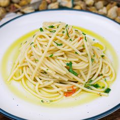 a white plate topped with pasta and garnished with parsley