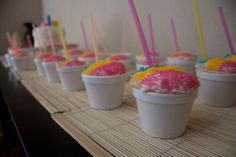 cupcakes with colored frosting are lined up on a table