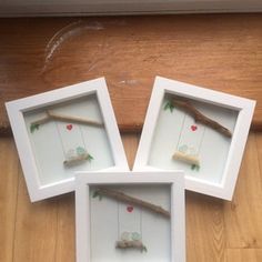 three white frames with small birds on them