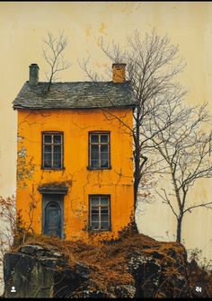 an old yellow house sitting on top of a hill