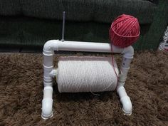 a yarn spool sitting on top of a table next to a ball of yarn