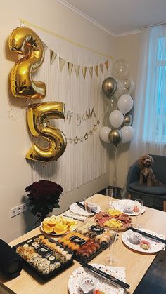 the table is set up for a 50th birthday party with balloons and food on it