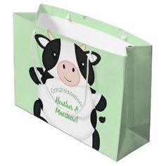 a green shopping bag with a black and white cow on it