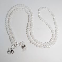 Keep your glasses or your mask close by with this Beaded Chain. It is a perfect way to brighten up any outfit.  It measures approx. 28 inches. It is made with white 6 mm (medium size) faux pearl beads. You can choose white rubber eyeglass holders for glasses and sunglasses, silver lobster clasps for holding masks, or both to be able to use either way. It is made with 49 strand jewelry wire for maximum durability. All of my items are handmade in Prince Edward Island, Canada. Shipping Information Beaded Glasses Chain, Beaded Glasses, Beaded Sunglasses, Eyeglass Necklace, Glasses Strap, Glasses Chains, Mask Necklace, Eyeglass Chain, Eyeglass Holder