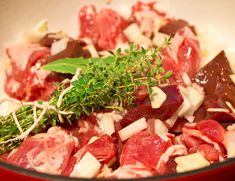 a bowl filled with meat and vegetables on top of a table