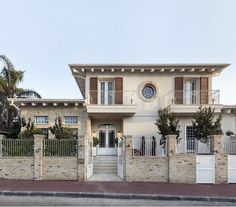 a large house with a clock on the wall and two balconies above it