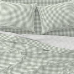 a bed with green and white checkered sheets, pillowcases and comforter