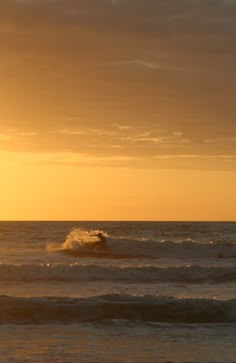 the sun is setting over the ocean with waves