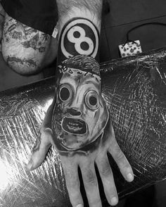 a hand with a face painted on it and an eight eight symbol in the middle