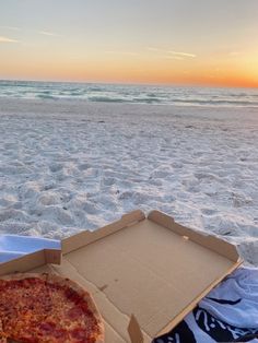 a pizza in a box on the beach