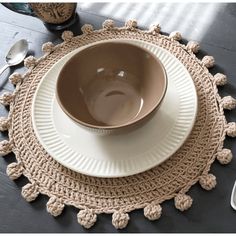 a bowl and plate on a placemat with spoons