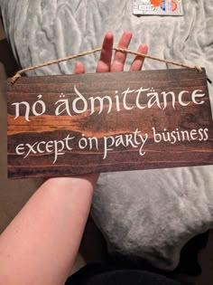 a sign that says no admittance except on party business hanging from a rope with someone's hand