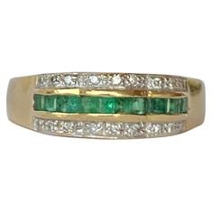 The square cut emeralds in this ring are beautiful and bright and measure 5pts each. Either side of the row of emeralds which are set in a scalloped setting are two rows of diamonds. Each row total approx 10pts of diamonds. The ring is modelled in 18carat gold. Ring Size: O or 7 1/4 Band Width: 6mm Weight: 3.39g Green Emerald Cut Rings With Half Eternity, Emerald Cut Green Diamond Ring With Multi-stone, Green Emerald Cut Multi-stone Diamond Ring, Emerald Cut Green Multi-stone Diamond Ring, Formal Channel Set Emerald Ring, Formal Green Emerald Ring With Half Eternity, Formal Green Channel Set Emerald Ring, Channel Set Emerald Cut Emerald Ring, Classic Green Multi-stone Diamond Ring