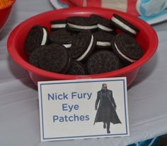 there is a bowl of cookies on the table with signs in front of it that read nick fury eye patches