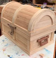 an unfinished wooden chest sitting on top of a table