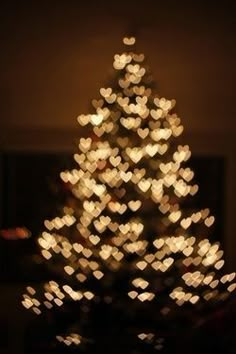 a christmas tree with lights in the shape of hearts on it's bottom and merry christmas written across the top